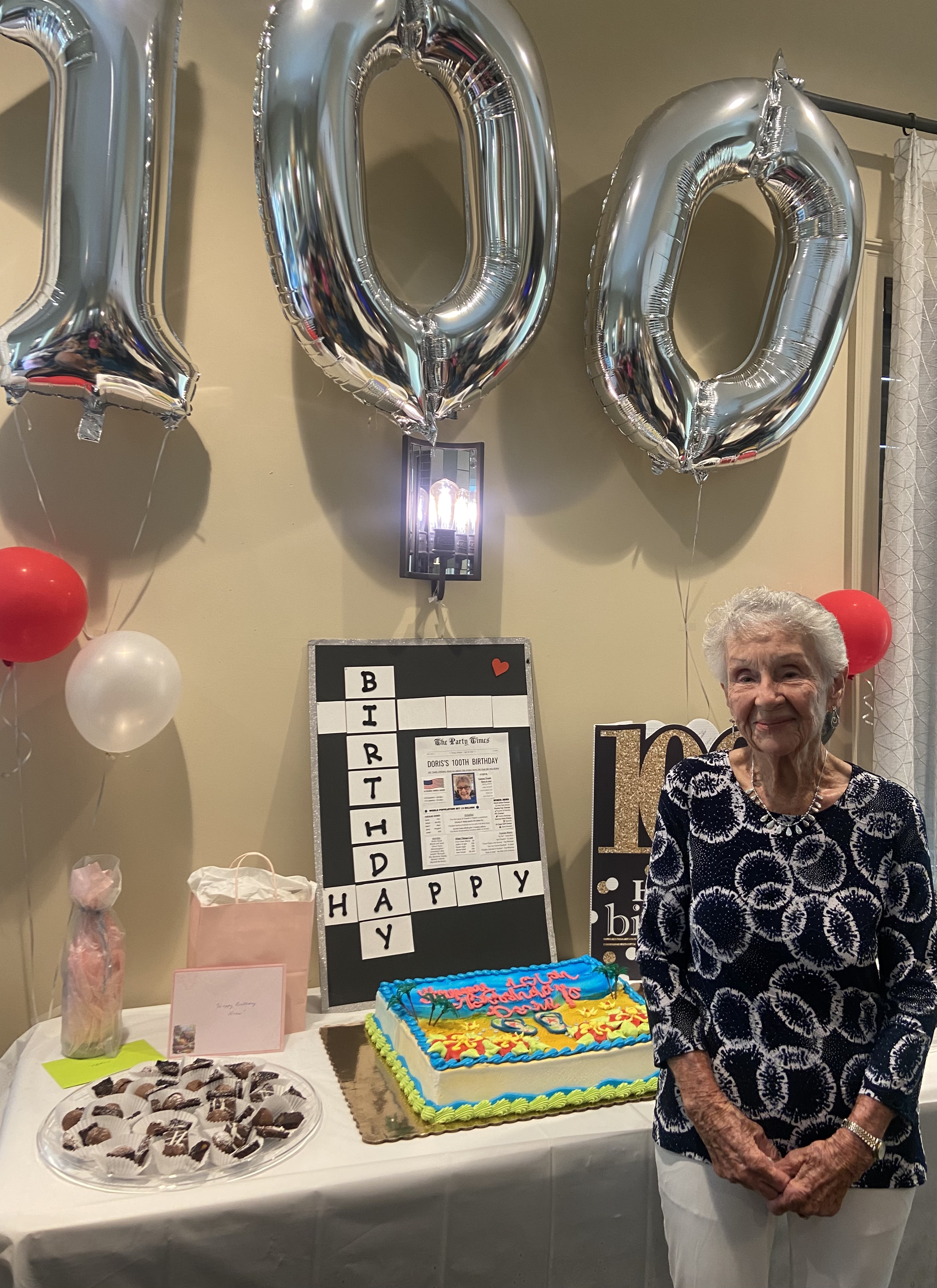 A resident smiles beside festive birthday decorations and balloons, celebrating a special milestone at senior living in Citrus Park, FL.
