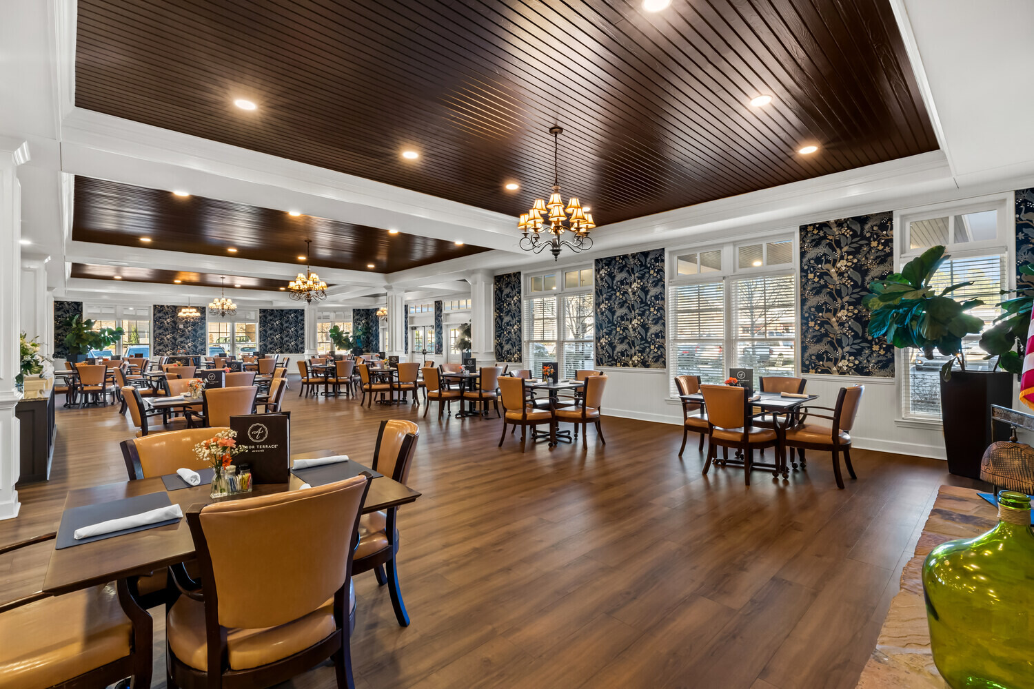 A warm and open dining and lounge space at this senior living community in Acworth, GA, featuring rich wood floors, layered lighting, and thoughtfully arranged seating for residents to gather and enjoy.