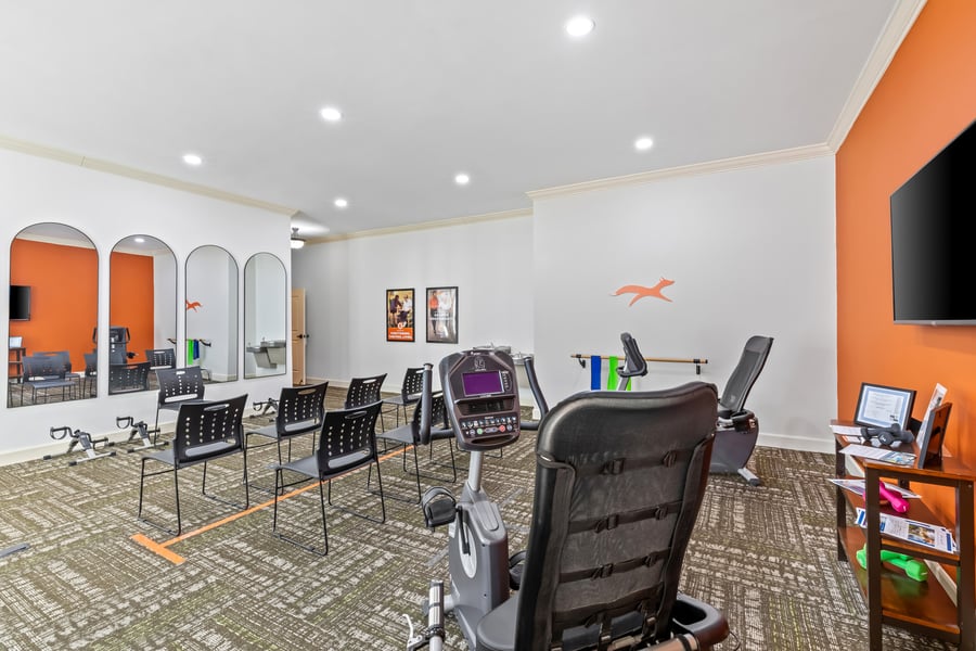 A well-equipped fitness room with cardio machines, chairs, and mirrors, supporting heart-healthy and active senior living at this assisted living community in Acworth, GA.