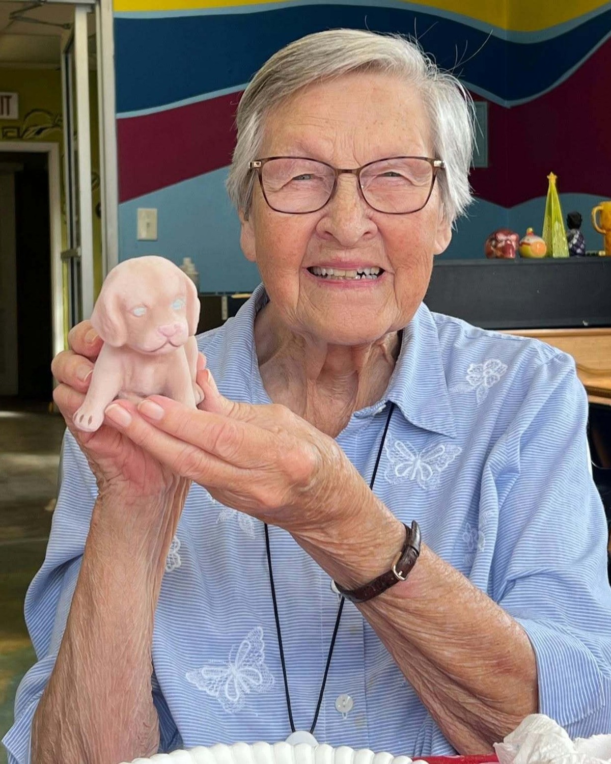 Resident smiling while holding a handmade craft piece at our senior living community in Acworth, GA, part of our engaging senior lifestyle programs