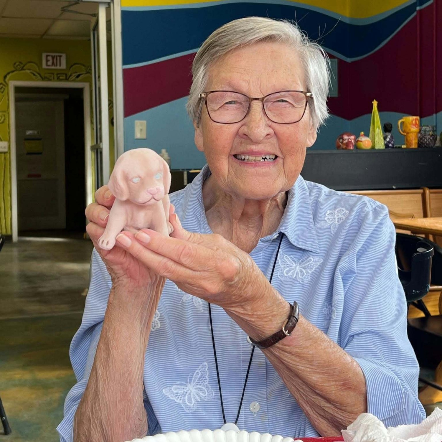 Resident smiling while holding a handmade craft piece at our senior living community in Acworth, GA, part of our engaging senior lifestyle programs