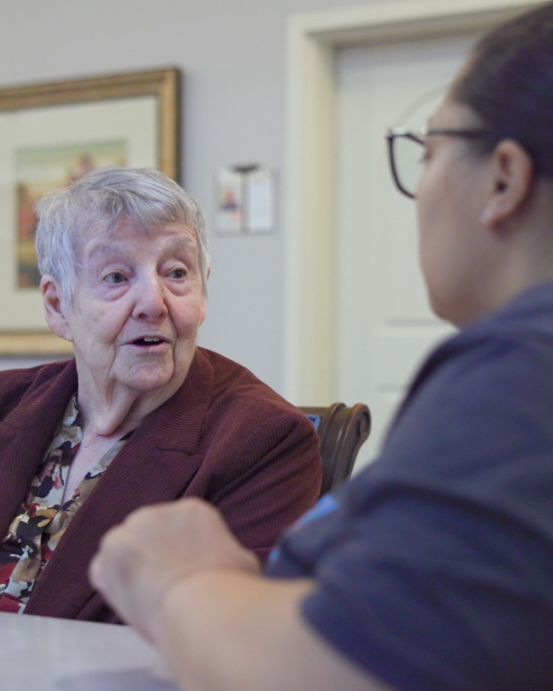 Resident sharing a warm conversation with a staff member at our senior living community in Acworth, GA, part of our engaging senior lifestyle programs