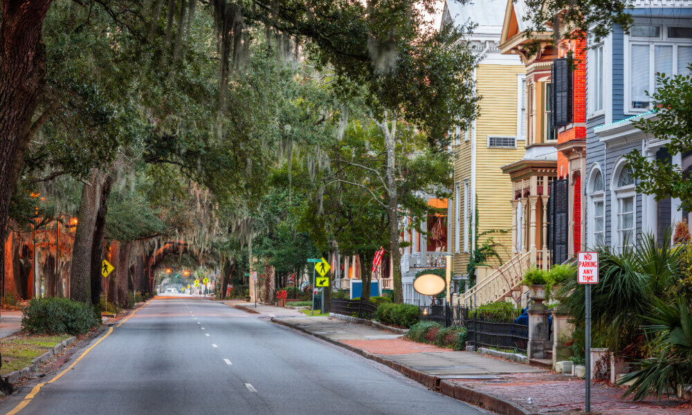 A tree-canopied historic avenue near this Acworth senior living community, lined with colorful Victorian-style homes and lush greenery, showcasing the walkable, neighborhood charm of the surrounding area.