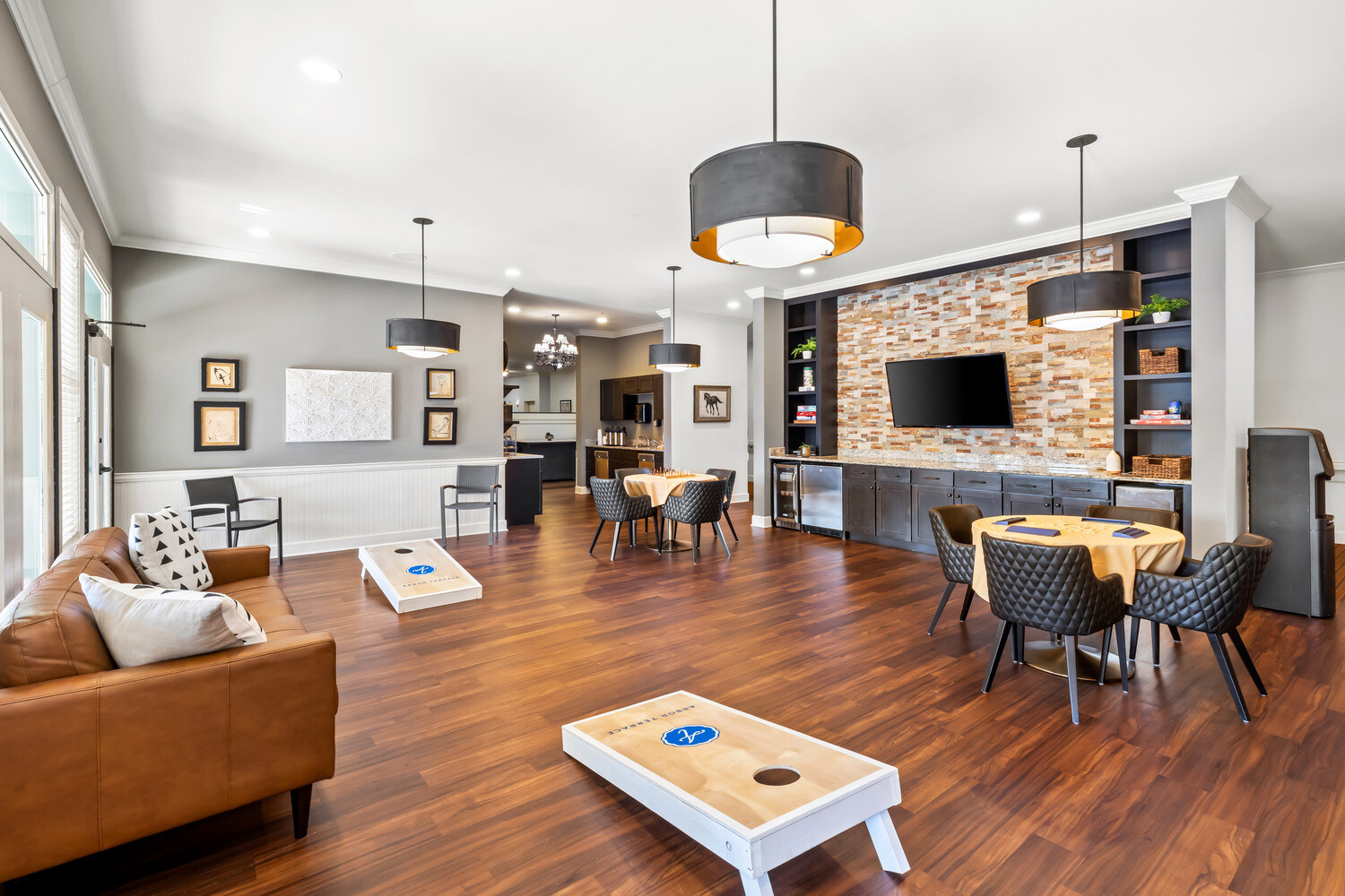 A comfortable game and lounge area at this senior living community in Acworth, GA, featuring a stone fireplace, flat-screen TV, and open layout with cozy seating perfect for social activities.
