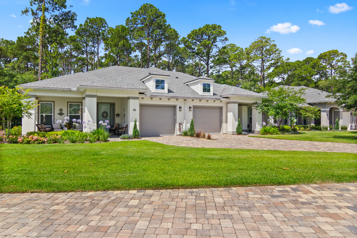 A charming single-story cottage home surrounded by lush green landscaping and a paved driveway reflects the residential warmth of The Lakeside at Amelia Island.