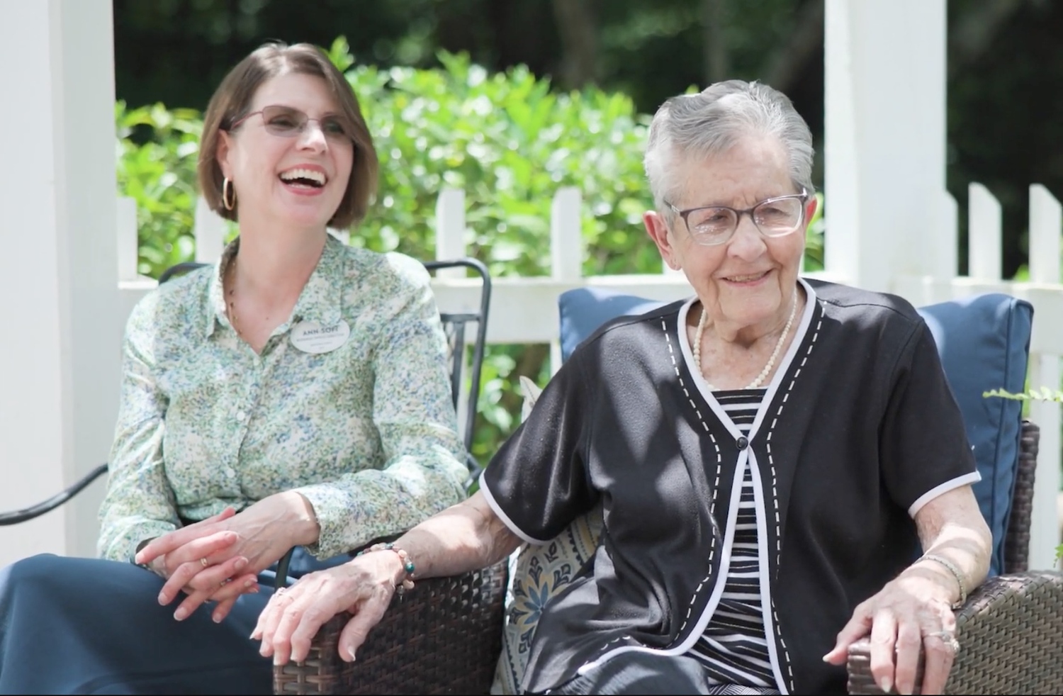 Arbor Terrace Athens team member sits next to smiling resident