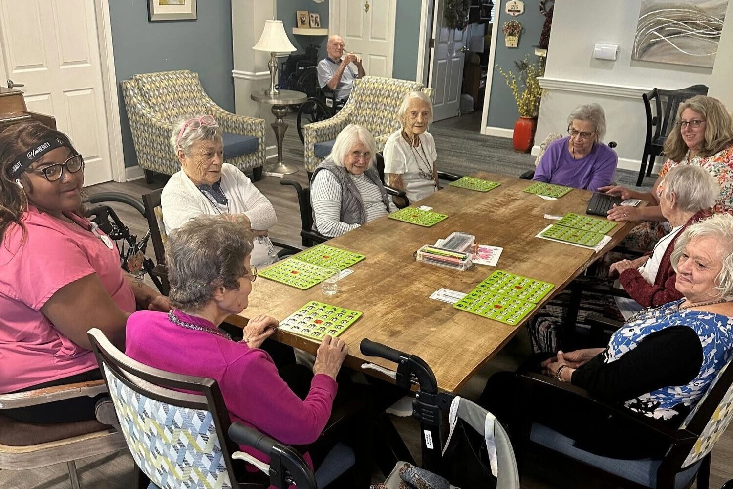 A group of residents gathers around a long table for a lively game of bingo at a senior living community in Athens, GA.