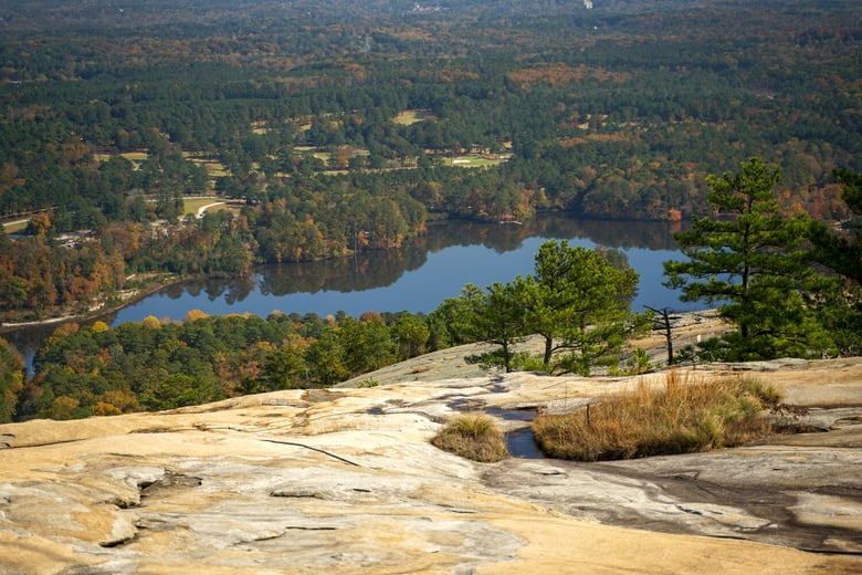 A scenic aerial view of a forested lake and rocky outcrop near Jefferson, GA, close to Arbor Terrace Athens, offering senior living in Jefferson, GA and senior living in Athens, GA.