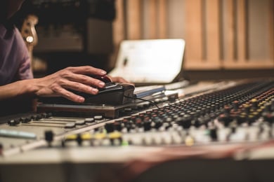 A hand adjusts a sound mixing board at The Classic Center, a top Athens performing arts venue enjoyed by Arbor Terrace Athens residents, reflecting the community's senior living with social engagement in Athens, GA.