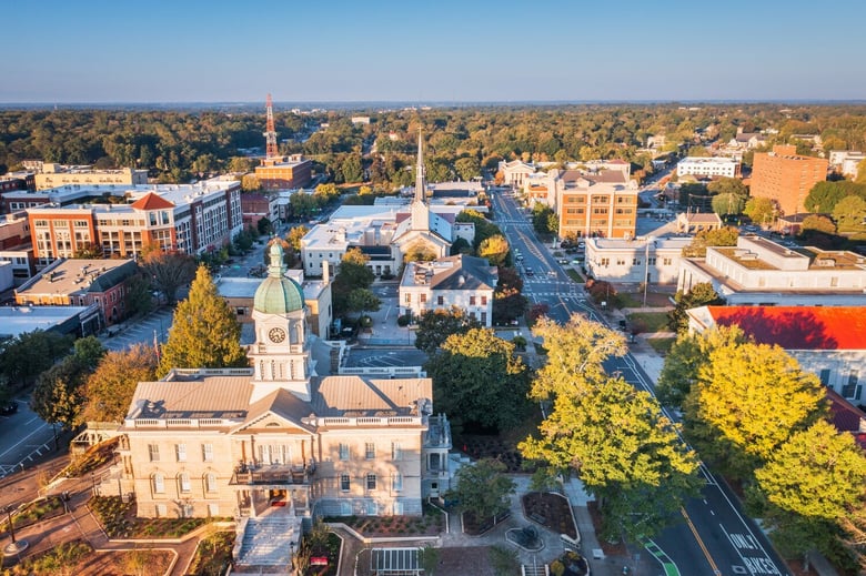 An aerial view of downtown Athens, GA, with a historic church spire and autumn foliage, home to Arbor Terrace Athens, offering senior living in Athens, GA and senior communities near downtown Athens, GA.