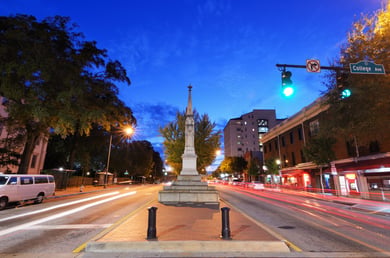 A scenic downtown Athens street glows at dusk near a historic monument, showcasing the vibrant senior living near downtown Athens, GA that Arbor Terrace Athens residents enjoy exploring.
