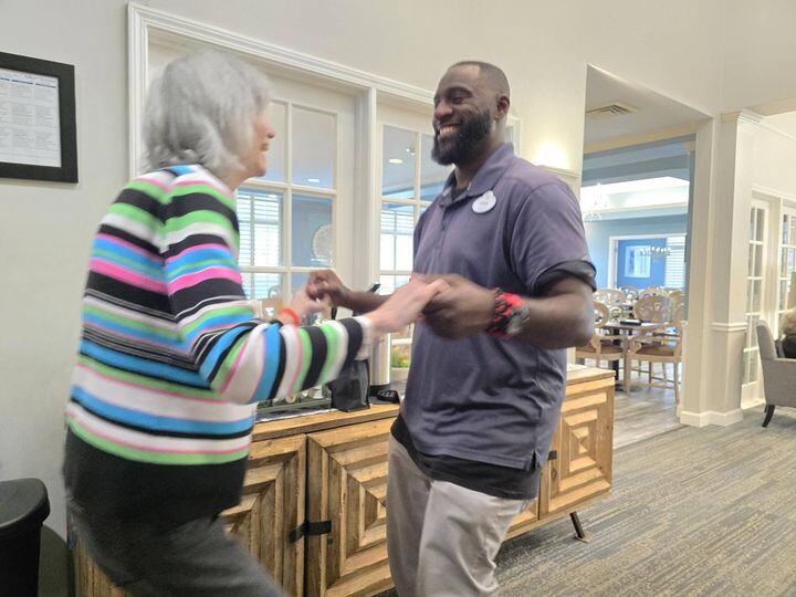 A resident and a staff member share a joyful dance together in a common area at Arbor Terrace Athens, capturing the warm, connected spirit of this assisted living community in Athens, GA.