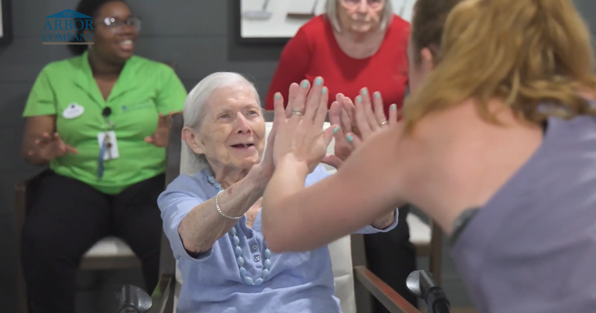 Resident smiling while getting a high five from a staff member during a community activity