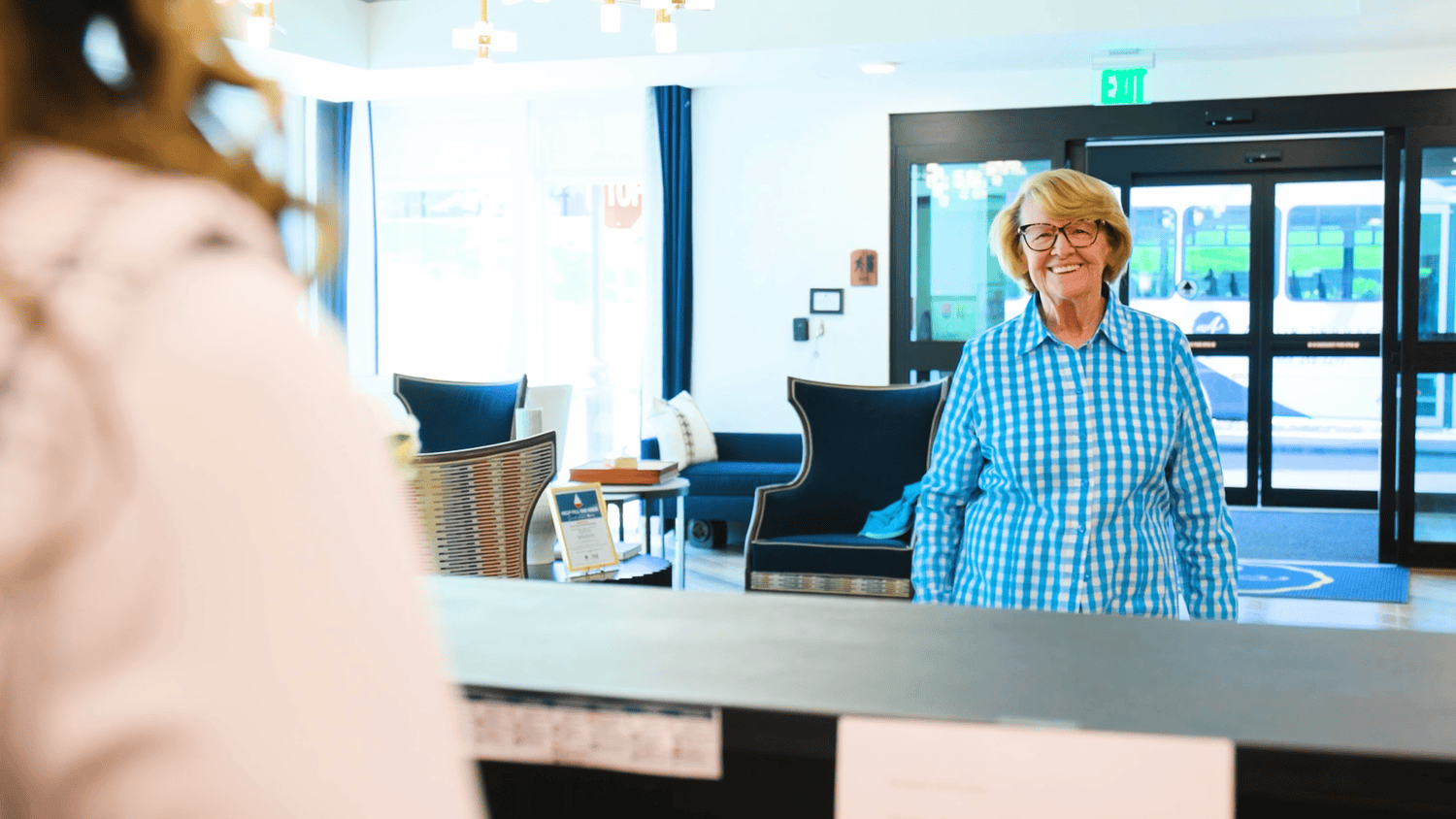 resident walking up to the front desk where a staff member is there to assist  