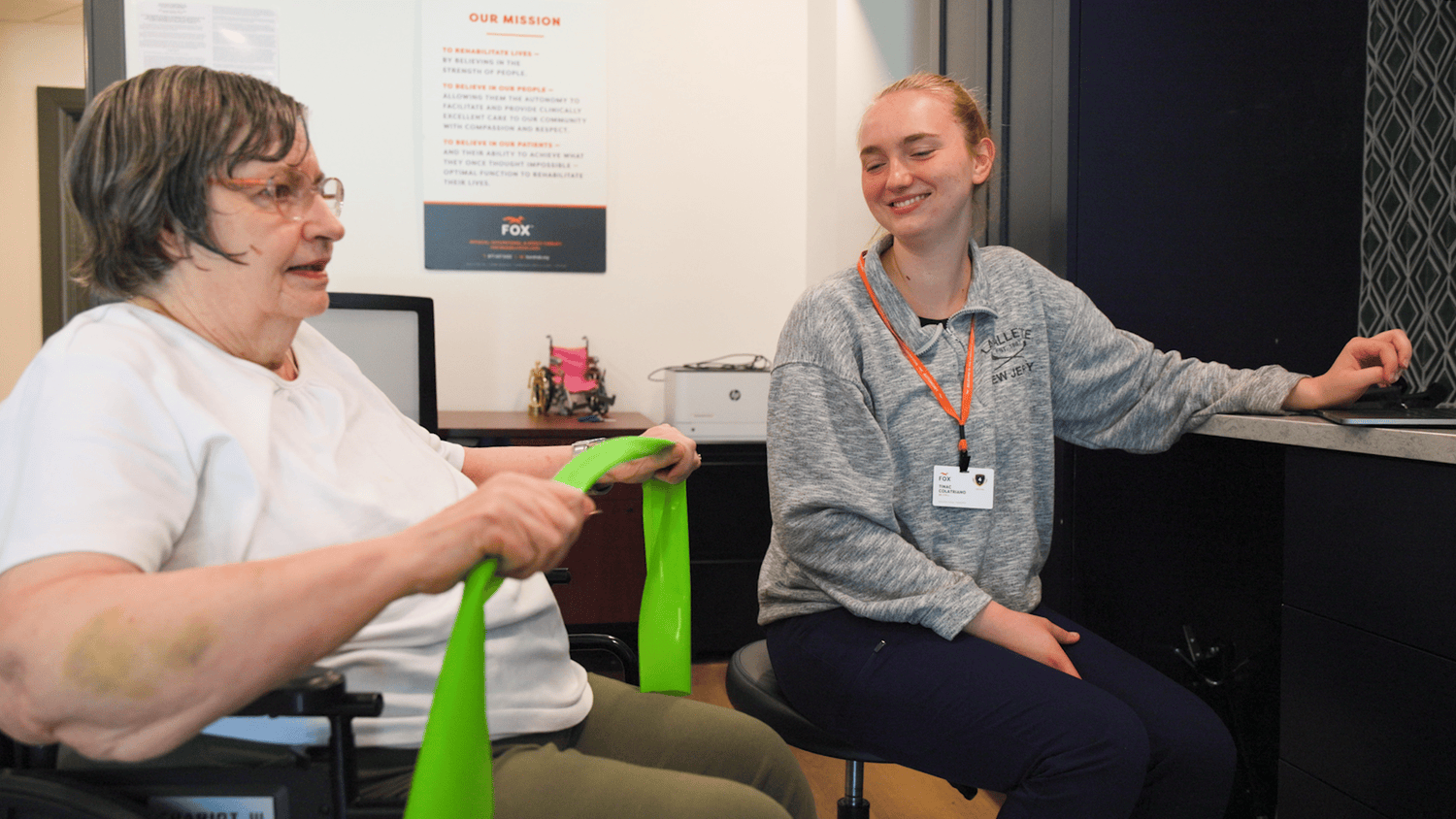 Resident and staff member using a band during a fitness class 