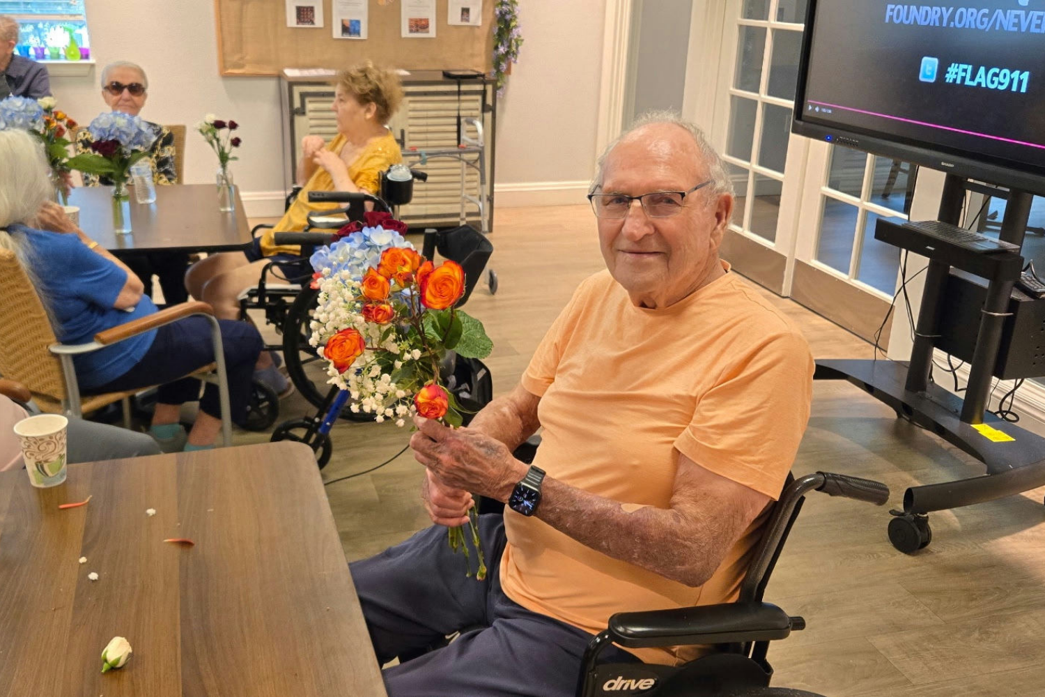 A smiling resident proudly holds a fresh bouquet of colorful flowers, capturing a heartfelt moment of community and connection at senior living in Citrus Park, FL.
