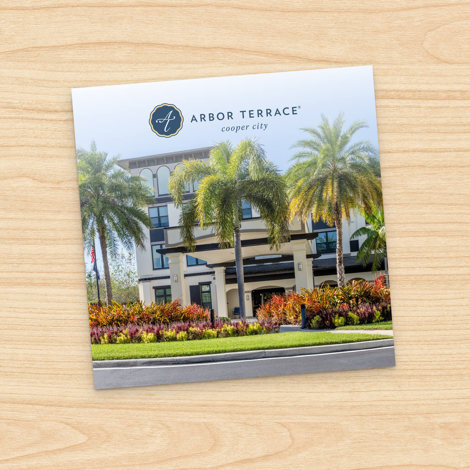Brochure cover for Arbor Terrace Cooper City showcasing the palm-lined exterior and vibrant landscaping, highlighting senior living in Cooper City, FL, and senior living near parks and recreation in Cooper City, FL.