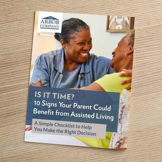 Cover of The Arbor Company guide titled "Is It Time? 10 Signs Your Parent Could Benefit from Assisted Living — A Simple Checklist to Help You Make the Right Decision," featuring two older women smiling warmly at each other.