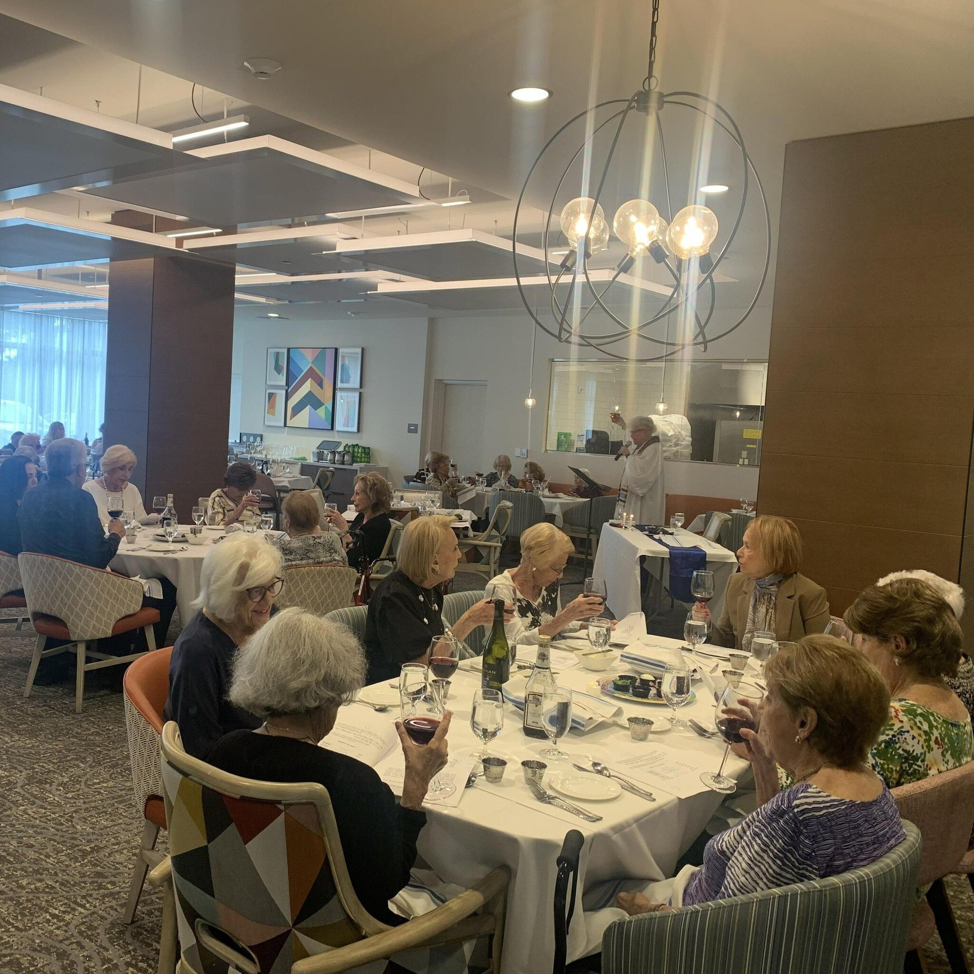 Residents enjoy a lively meal together in the elegantly appointed dining room at The Arbor at Delray, reflecting the resort-style amenities and warm social engagement of senior living in Delray Beach, FL.