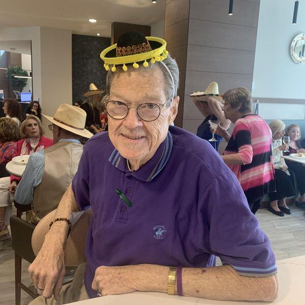 A resident smiles warmly while wearing a festive sombrero at a themed celebration, capturing the fun and vibrant social engagement at this active senior living community in Delray Beach, FL.