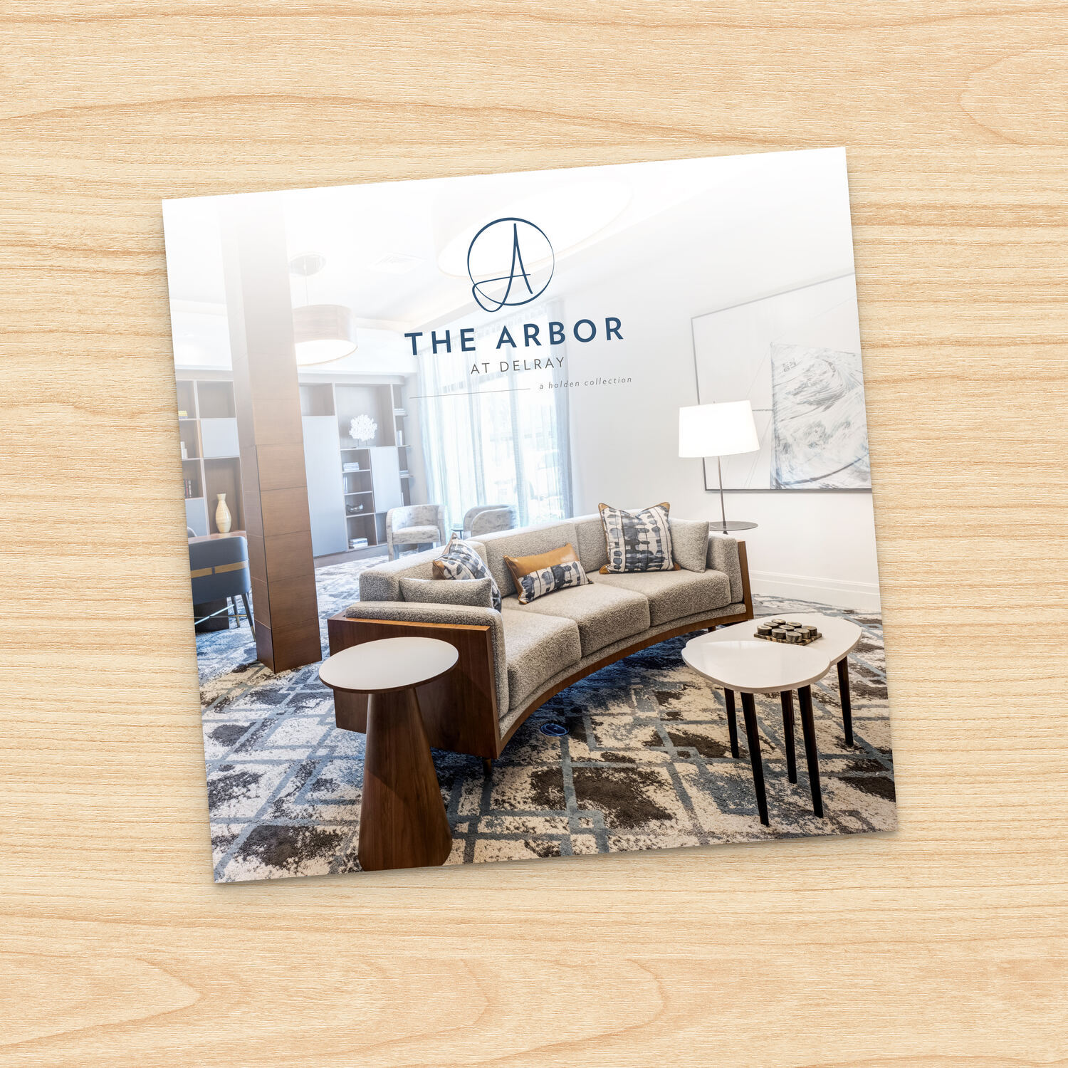The Arbor at Delray guide  cover displays a stylish, sunlit lounge area with modern furniture and layered textiles, offering a glimpse into the elegant common spaces of this senior living community in Delray Beach, FL.