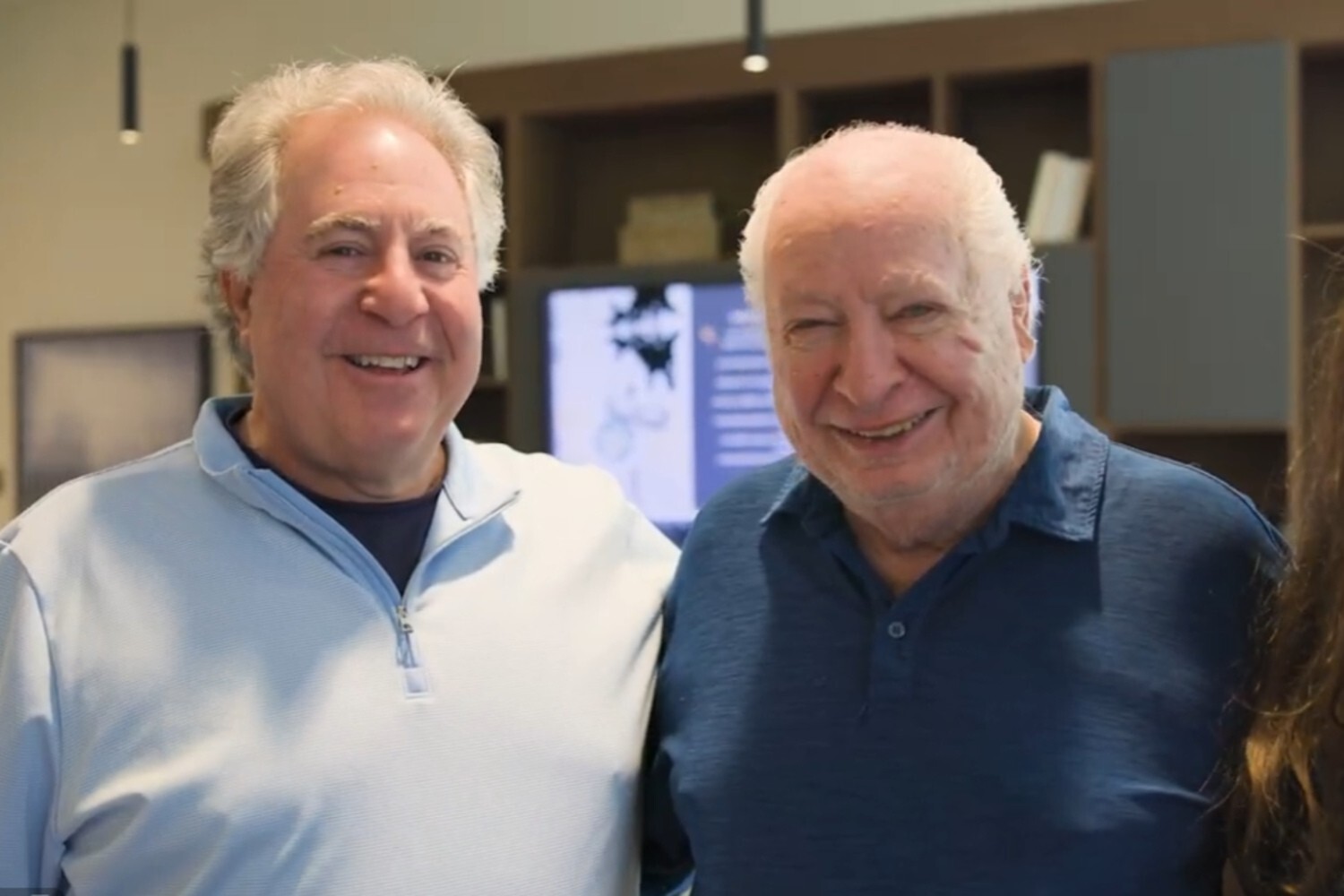 Two men smile warmly together in a comfortable common area at The Arbor at Delray, capturing the genuine connections and welcoming spirit of senior living in Delray Beach, FL.