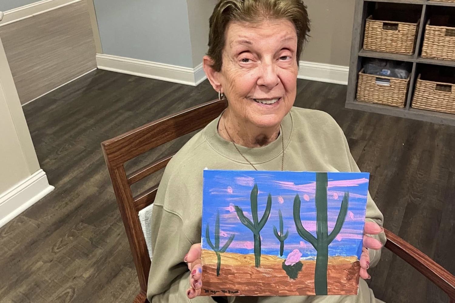 a female resident showing her painting of a desert