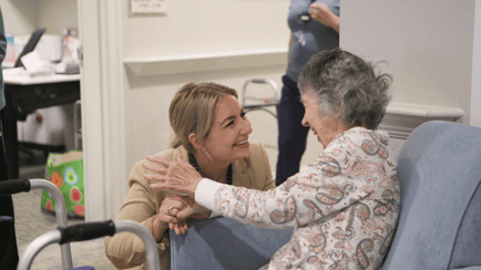 A senior female resident speaking with a woman