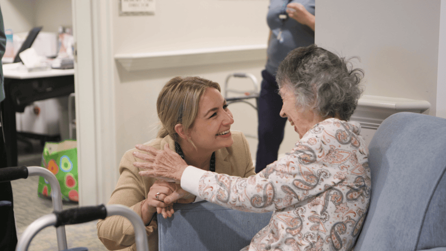 A senior female resident speaking with a woman