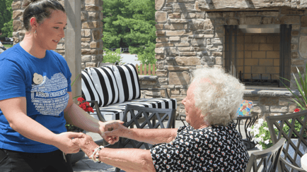 A senior lady holding hands with staff lady