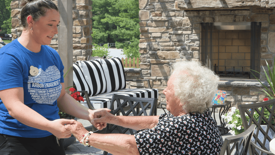 A senior lady holding hands with staff lady
