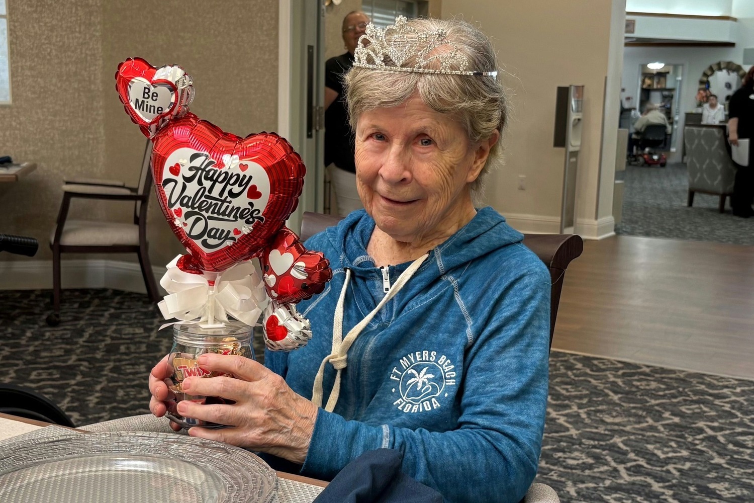 A resident takes aim at an axe-throwing target while a staff member cheers them on, showcasing the fun and active programming offered at a senior living community in Fort Myers, FL.