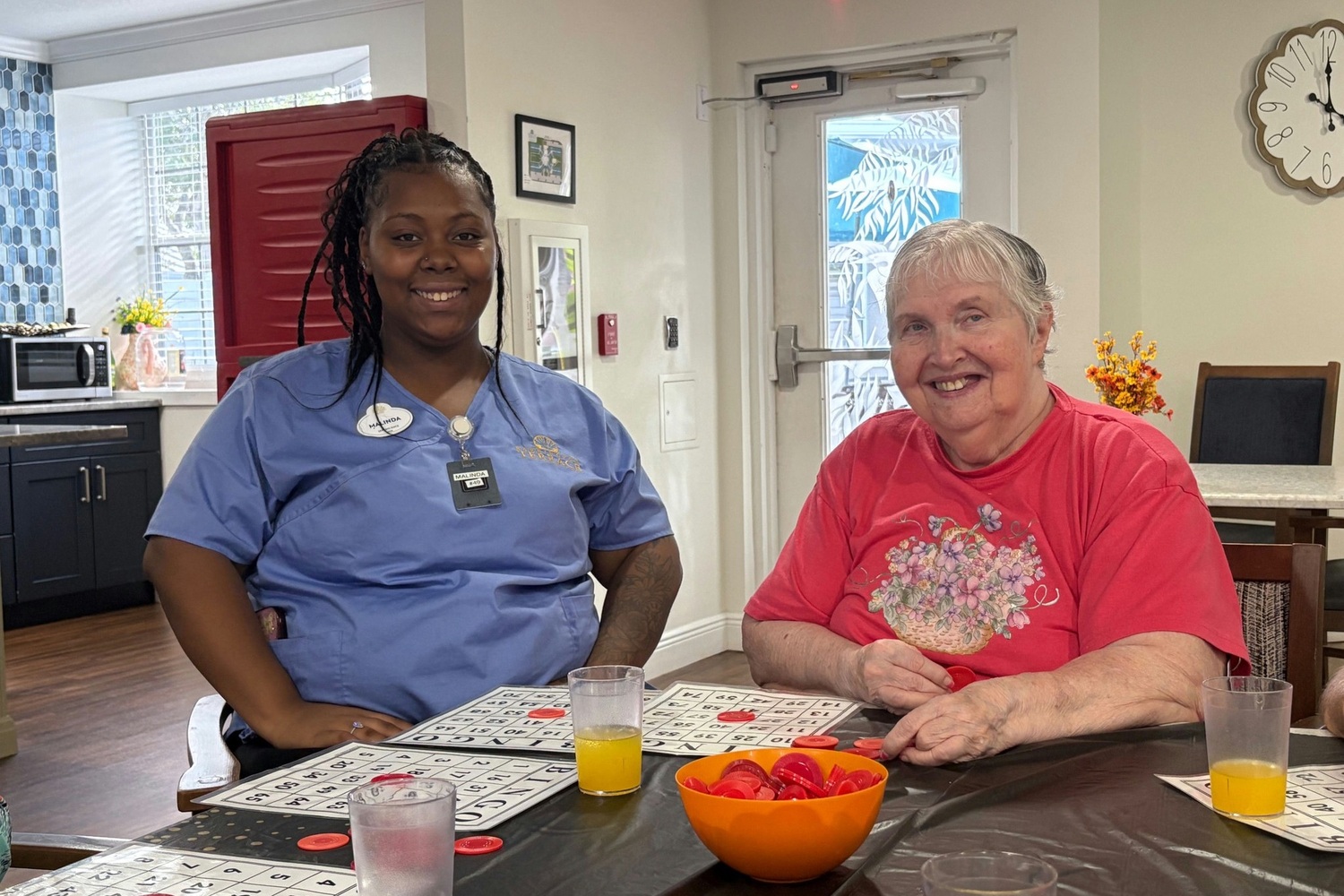 A staff member plays bingo alongside a resident who smiles warmly at this assisted living community in Fort Myers, FL.