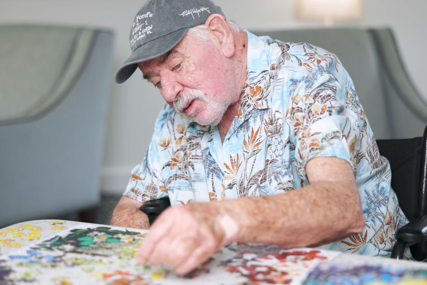 A resident focuses on a colorful puzzle at a table at Barrington Terrace senior living in Fort Myers, FL.