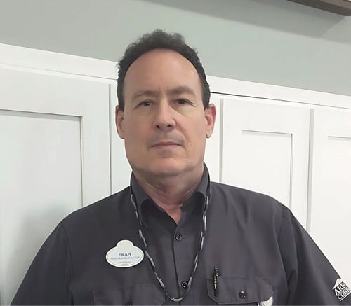 A staff member wearing a name badge and gray uniform shirt at Barrington Terrace assisted living in Fort Myers, FL.