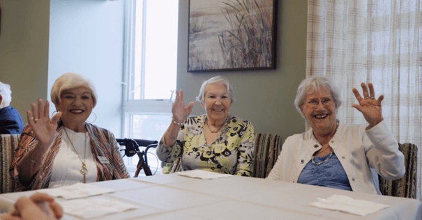 a group of senior ladies waving their hand