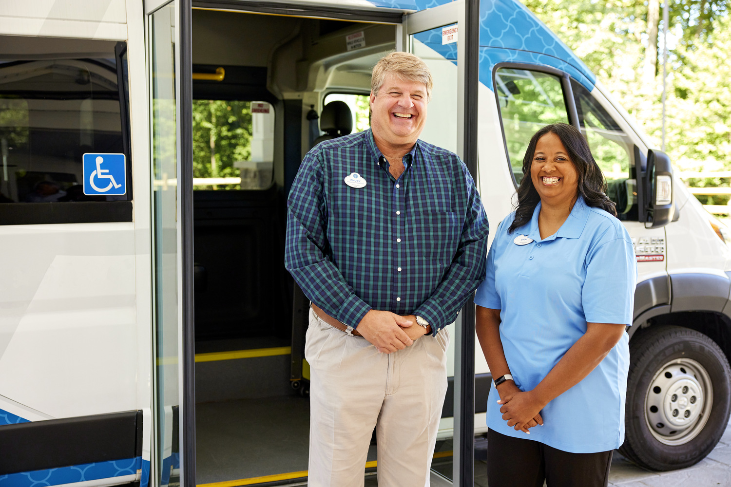 Staff members smiling in front of bus