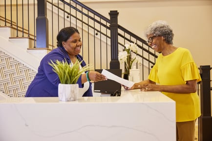 Resident at the front desk talking to a staff member