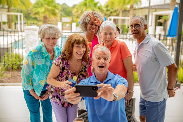 Residents taking a selfie on an iphone in front of pool area