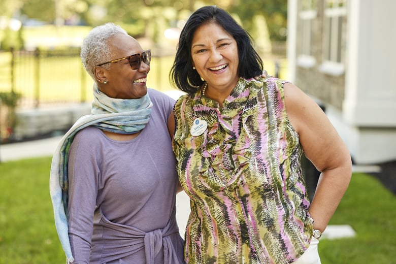 Resident and staff member smiling outside