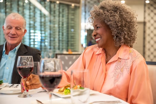 Smiling residents dining with red wine and food