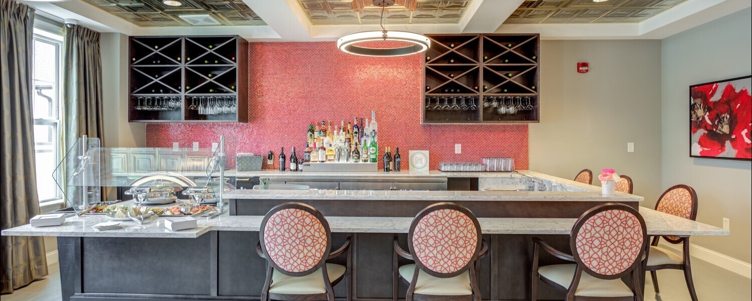 The bar lounge at Arbor Terrace Glenview senior living offers a stylish spot with wine displays and cozy seating, part of the community assisted living in Glenview Illinois amenities.
