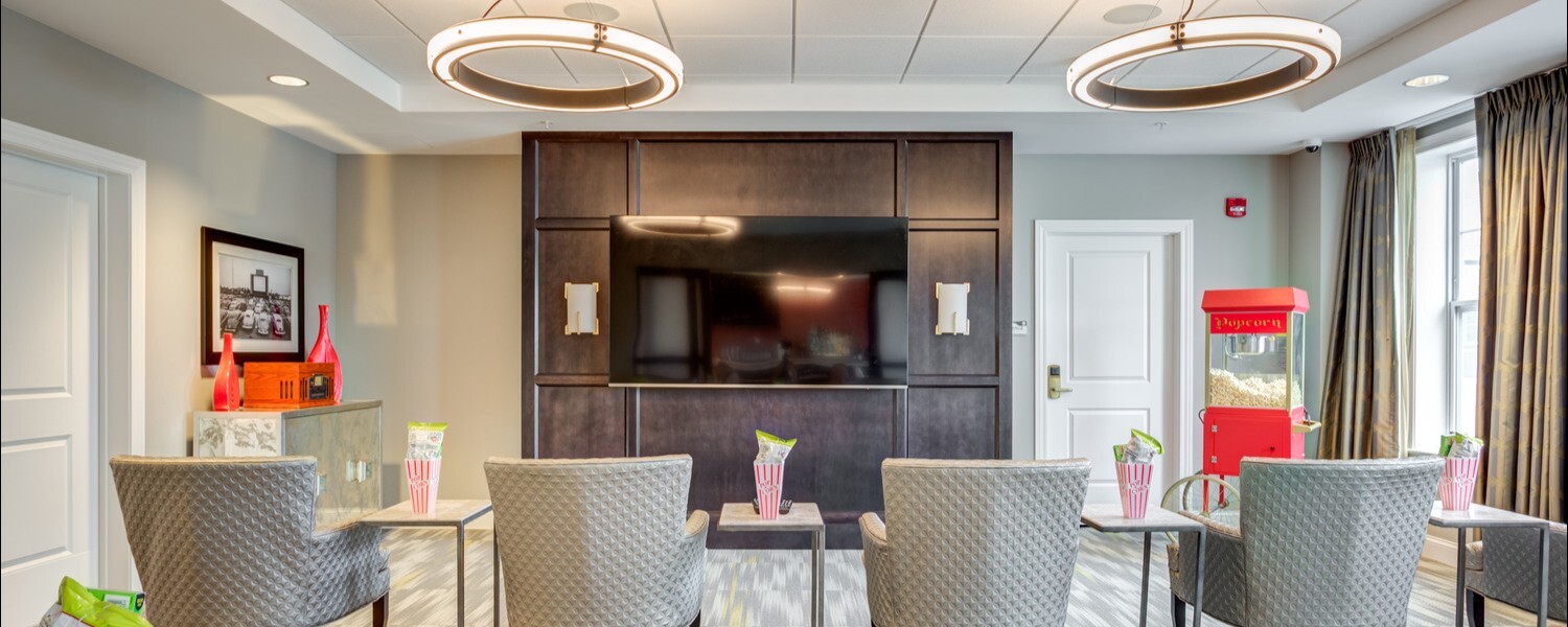 The common area at Arbor Terrace Glenview senior living includes a cozy theater style lounge with plush seating, offering comfortable senior living with wellness programs Glenview IL.