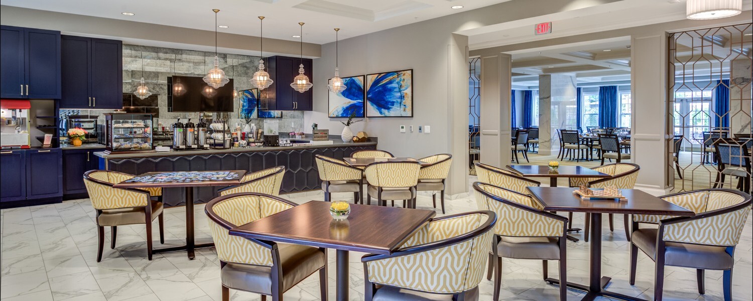 The dining area at Arbor Terrace Glenview senior living features a bright cafe style counter and seating, showcasing senior living with gourmet dining North Shore.