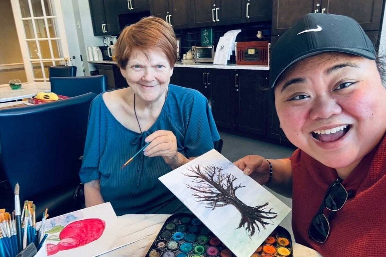 Two community members enjoy a painting activity together at this Glenview senior living community, working on tree-themed artwork, part of the wellness programs available at this top-rated Glenview senior living community.