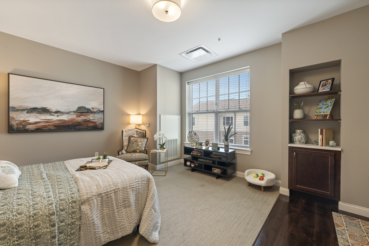 The bedroom at Arbor Terrace Glenview senior living features a bright window and built-in shelving, part of the assisted living in Glenview Illinois lifestyle.