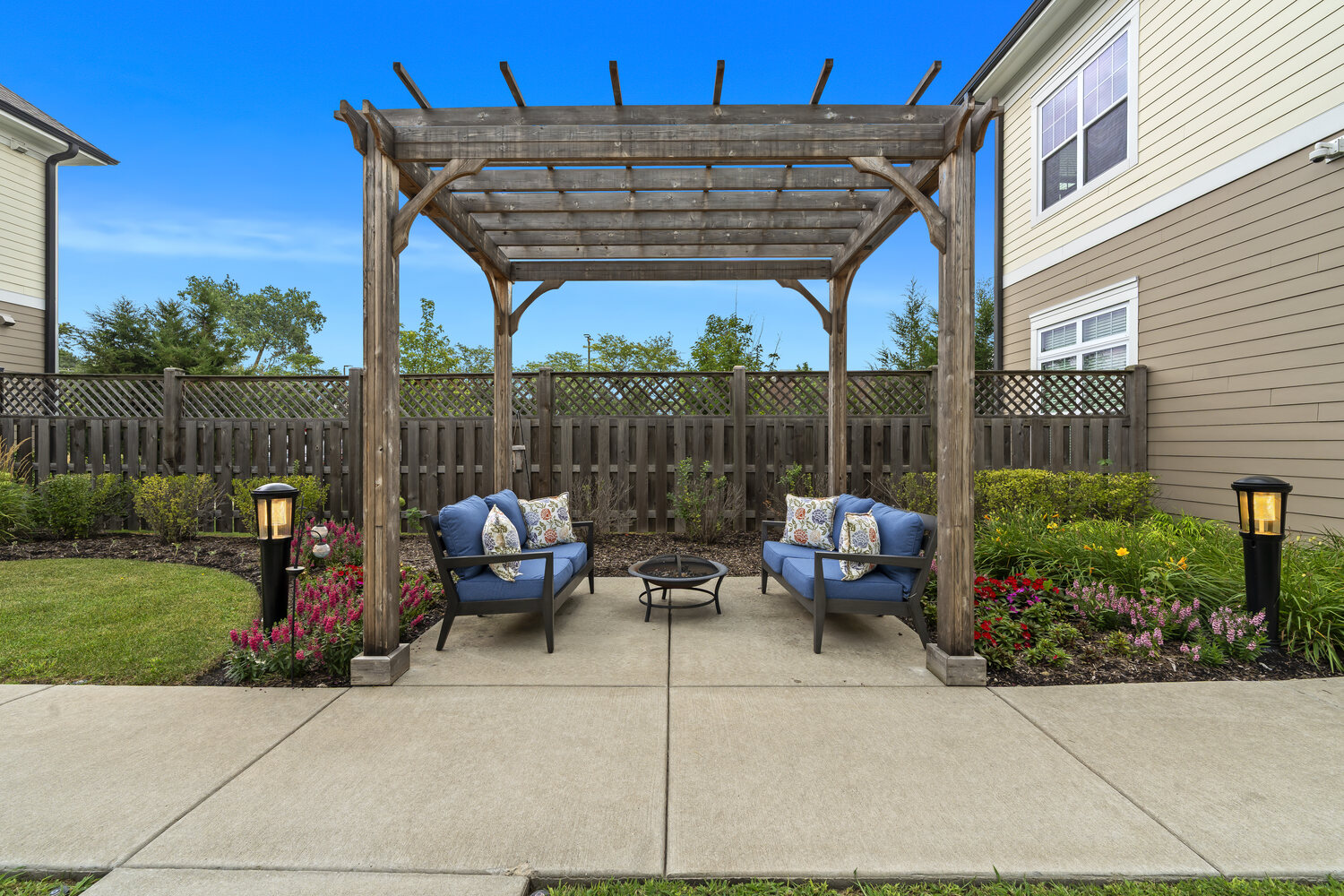 The pergola patio at Arbor Terrace Glenview senior living features comfortable seating surrounded by lush gardens, part of senior living near forest preserves Glenview.