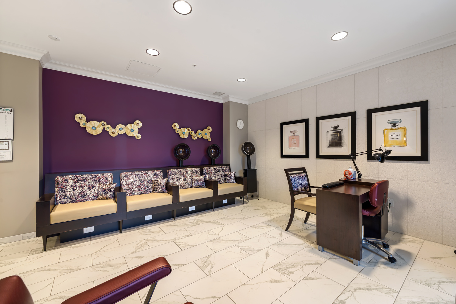 The salon waiting area at Arbor Terrace Glenview senior living offers comfortable seating beneath a bold accent wall, reflecting senior living with wellness programs Glenview IL.