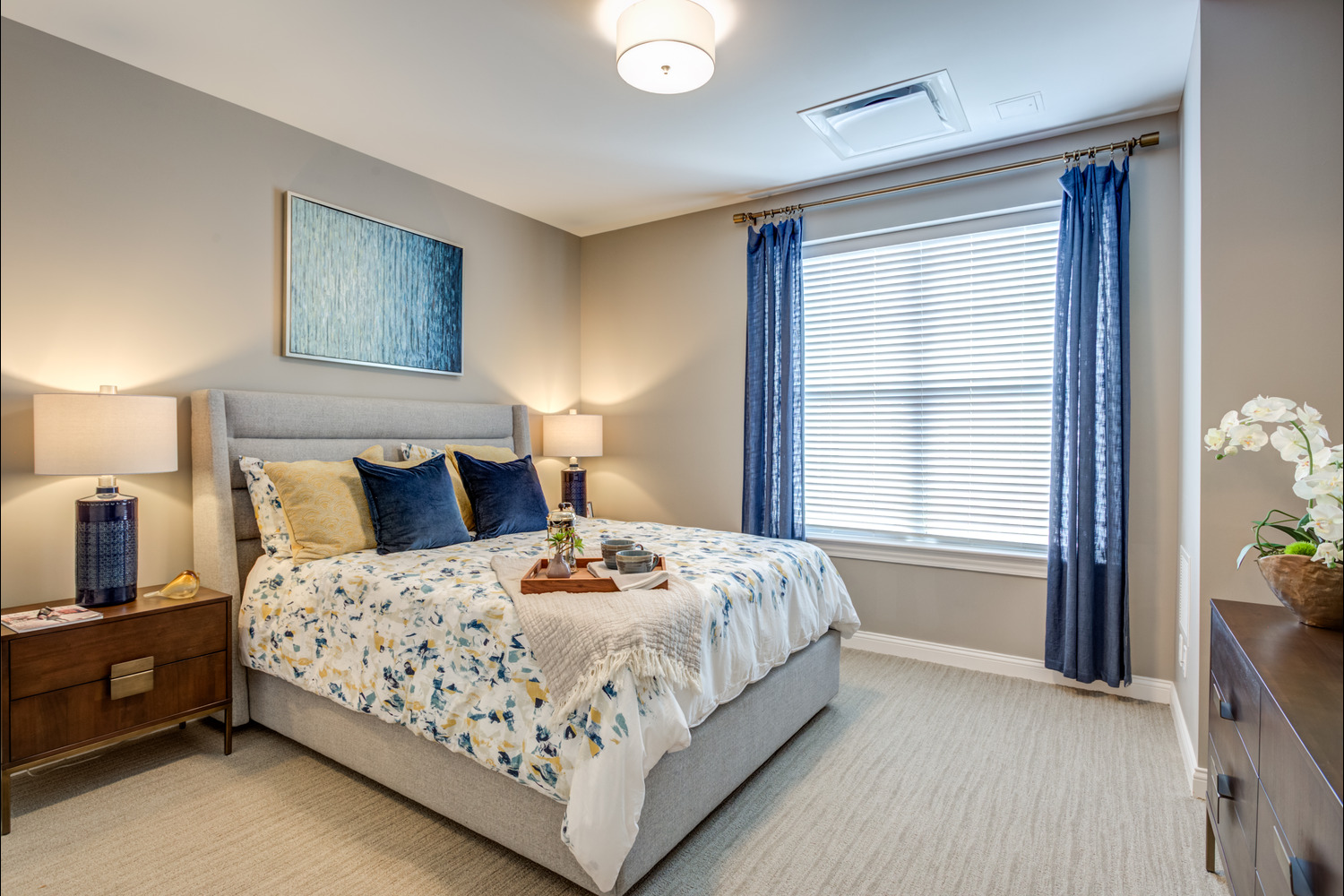 The bedroom at Arbor Terrace Glenview senior living showcases elegant bedding and tasteful artwork, reflecting the assisted living in Glenview Illinois experience.