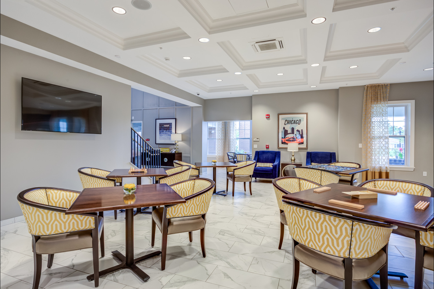 The dining room at Arbor Terrace Glenview senior living features comfortable seating and tasteful artwork, part of the assisted living in Glenview Illinois lifestyle.
